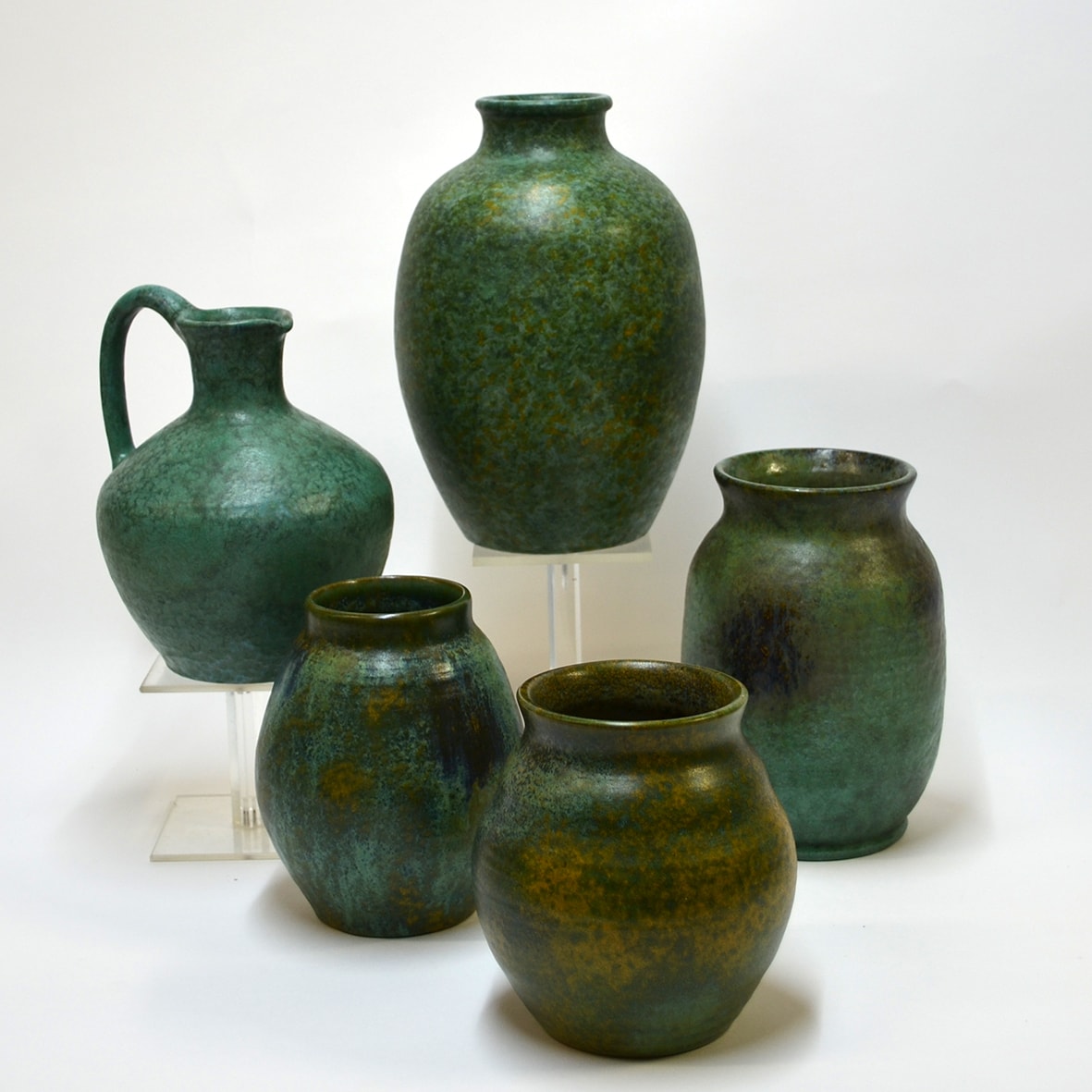 Handgedraaide potterie op een roodbakkende scherf met groene, schiftende matglazuren